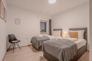 een slaapkamer met twee bedden en een stoel en een raam bij Vipava River Retreat - Happy Rentals in Vipava +33 foto's
