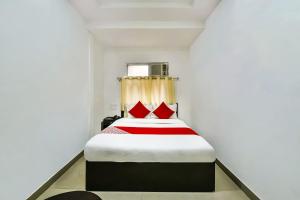 a bedroom with a bed with red pillows at Hotel O Tirupati Residency Kota Airport in Kota