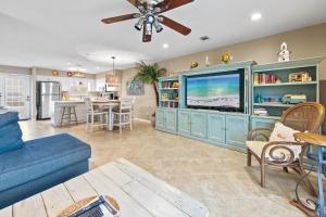 a living room with a blue entertainment center with a flat screen tv at Summerlake 29 in Destin