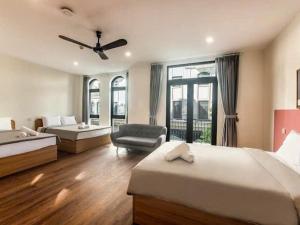 een hotelkamer met twee bedden en een stoel bij Hotel G7 Ocean Park 2 in Ðình Loan