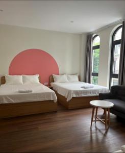 een slaapkamer met 2 bedden en een bank en een tafel bij Hotel G7 Ocean Park 2 in Ðình Loan