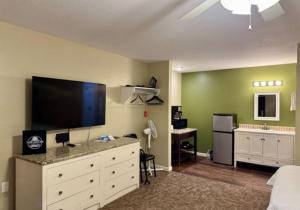 a bedroom with a large television and a white dresser at Twin Lakes Inn & RV Park in Stigler