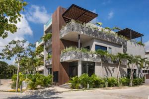 图卢姆6BR Villa at Premium Location 24 h Security的侧面有植物的建筑物