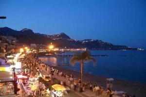 a crowd of people on a beach at night at Casa Motta Camastra, panoramahouses, prive zwembad en prachtige vergezichten in Linguaglossa