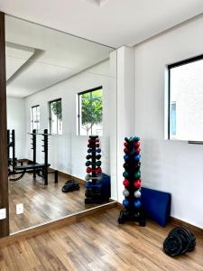 ein Raum mit Spiegel und Fitnessgeräten in der Unterkunft Apto Moderno com 2 quartos em Londrina in Londrina