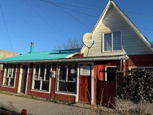 an old red building with a steeple on top of it at Valentine's Day Host Mary Leo Accommodation House in Cochrane