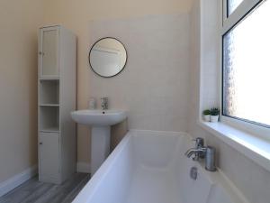a bathroom with a tub and a sink and a mirror at Seaside Villa in Bridlington +12 photos