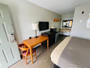 ポート・ウェントワースにあるSavannah Inn - Savannah I-95 Northのベッドと机とテレビがあるホテルの部屋