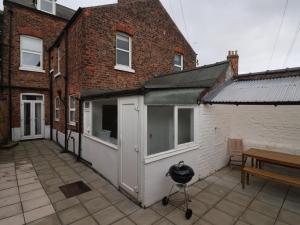 a patio with a white building and a bench at Seaside Villa in Bridlington