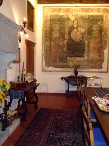 ein Wohnzimmer mit einem Gemälde an der Wand und einem Tisch in der Unterkunft Palazzo Tarlati - Hotel de Charme - Residenza d'Epoca in Civitella in Val di Chiana