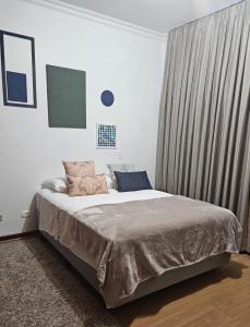 Un dormitorio con una cama grande con ventana. en Suíte confortável e prática, en São Paulo