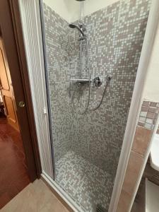 a shower with a glass door in a bathroom at Biddy's house in Ciampino +4 photos