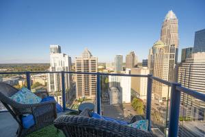 a balcony with two chairs and a view of the city at Uptown Penthouse in Charlotte