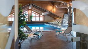 a swimming pool with two chairs and a table at Rochu 10 personnes Spa, Calme & Vue Montagne in Champagny-en-Vanoise