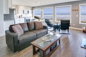 Ocean Front with Beautiful Views! The Beach House-Seal Rock في Bayshore: غرفة معيشة مع أريكة وطاولة