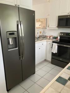 a kitchen with a stainless steel refrigerator and white cabinets at casaconejo 2 in Leeward