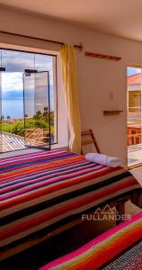 une chambre avec un lit avec vue sur l'océan dans l'établissement Casitas Amantani, à Ocosuyo