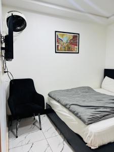 a bedroom with a bed and a black chair at Mc Lodge 