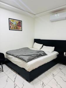 a bed in a room with a picture on the wall at Mc Lodge 