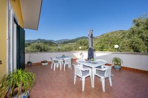 a patio with tables and chairs on a balcony at Mare Natura in Patti