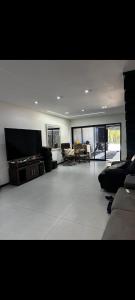 a large living room with a couch and a table at Apartamento aconchegante e moderno próximo do aeroporto e ao centro in Porto Seguro