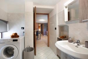 a bathroom with a washing machine and a sink at Maison Bebe Terre Blanche in Aosta