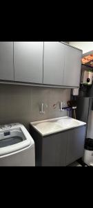 a small kitchen with a sink and a stove at Apartamento aconchegante e moderno próximo do aeroporto e ao centro in Porto Seguro