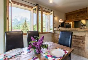 a dining room with a wooden table and chairs and a window at Ferme Le Coup d'Oeil in Taninges
