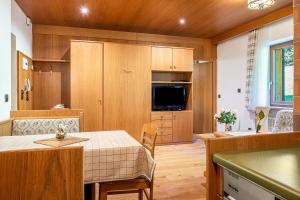 a kitchen and dining room with a table and a kitchen gmaxwell gmaxwell gmaxwell at Cesa Soramurat Appartamento 4 in Canazei