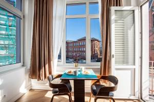 リューベックにあるAltstadt Residenzのテーブルと椅子と窓のある部屋