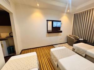a hotel room with two beds and a television at Cent Al Khair Hotel Makkah in Makkah