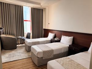 a hotel room with two beds and a window at Cent Al Khair Hotel Makkah in Makkah +36 photos