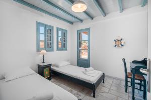 a bedroom with two beds and a desk and a chair at Ammos 1 in Serifos Chora