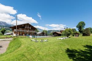 a large yard with chairs and a building at Chalet de la Marmotte in Crest-Voland