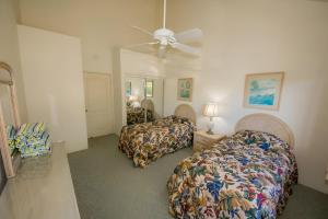 a bedroom with two beds and a ceiling fan at 6BR Poipu Kai Oceanfront Retreat Steps to 3 Beaches in Koloa +16 photos
