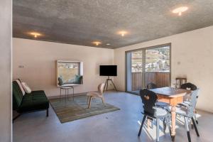a living room with a table and chairs and a couch at Lena Dolomites Suite in Villnoss