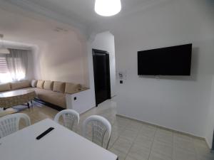 a living room with a couch and a tv on a wall at heartofrabat in Rabat