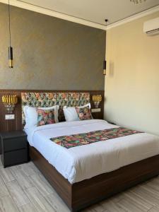 a bedroom with a large bed with a headboard at Amirale in Oran