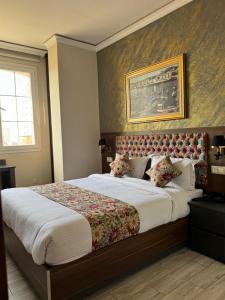 a bedroom with a large bed with a painting on the wall at Amirale in Oran