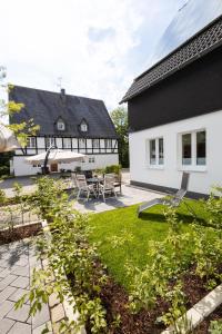 een achtertuin met een zwart-wit huis bij Conzen Hof am Hennesee in Meschede