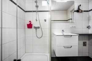 a white bathroom with a shower and a sink at Prerow Am Deich - Fewo 3 in Prerow +20 photos