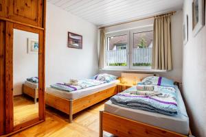 a bedroom with two beds and a mirror at Prerow Am Deich - Fewo 3 in Prerow