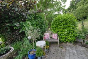 een bank in een tuin met planten bij Haus Am Sonnenhügel in Bad Urach