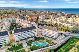 an aerial view of a city with buildings and the ocean at Puerto Romano in Denia