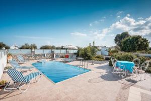a patio with chairs and a swimming pool at Green Pearl in Lachania