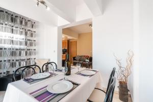 a dining room with a white table and chairs at Green Pearl in Lachania