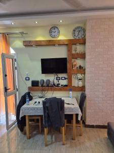 a dining room with a table and a tv on the wall at Star Apartment Hurghada in Hurghada