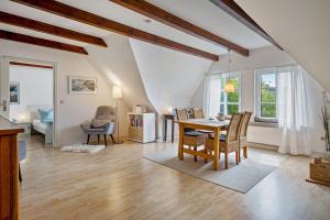 Una sala de estar con mesa de comedor y sillas. en Fewo Silbermöwe, en Pellworm
