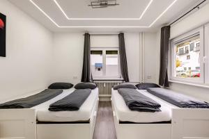 two beds in a room with two windows at Apartment Bollenhutzauber - Modern - Zentral - Parkplatz - Top bewertet in Gutach