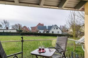 een tafel en twee stoelen op een veranda met een veld bij Strandlust Insel Poel in Insel Poel
